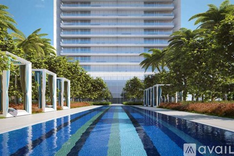 A long, blue and green tiled pool with white pillars on either side.