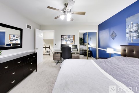 A bedroom with a large bed and a ceiling fan.