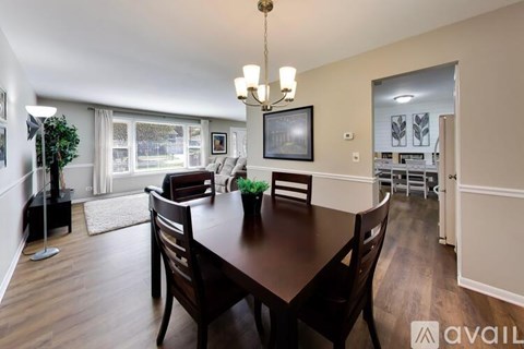 A dining room with a wooden table and chairs.