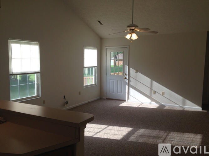 A room with a ceiling fan and a door leading to a balcony.