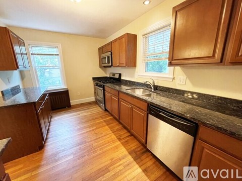 A kitchen with wooden cabinets and a black countertop.