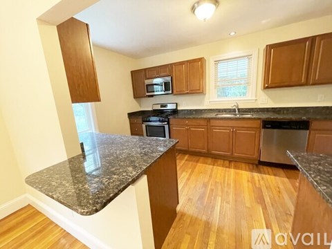 A kitchen with wooden cabinets and granite countertops.