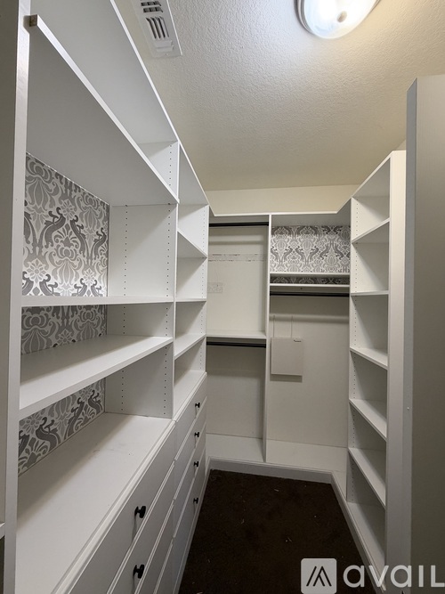 A white walk-in closet with shelves and drawers.