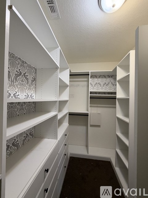 A white walk-in closet with shelves and drawers.