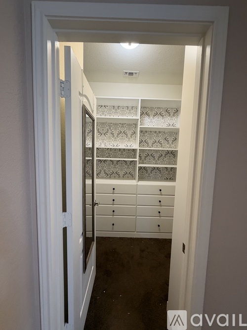 A white door is open to a room with a wall of drawers.
