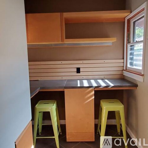 A kitchen with a table and two stools.