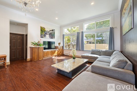 A living room with a grey couch and a coffee table in the middle.