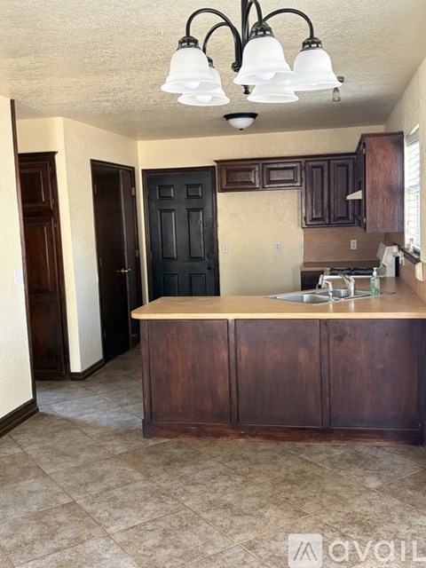 A kitchen with a sink and wooden cabinets.