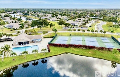 A bird's eye view of a residential area with a swimming pool and a tennis court.