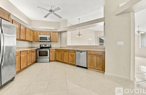 A kitchen with wooden cabinets and a refrigerator.