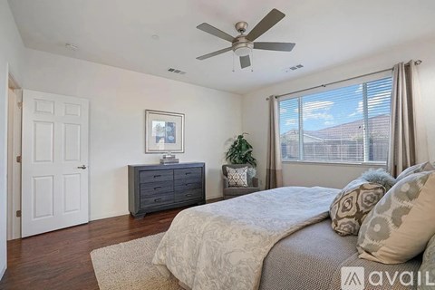 A bedroom with a bed, dresser, and window.