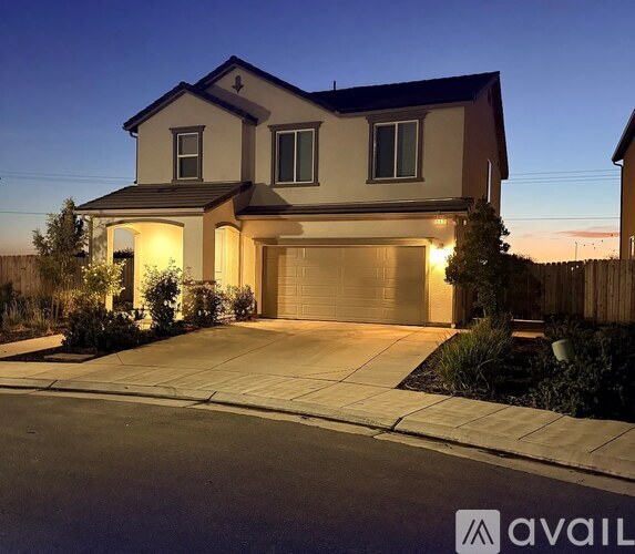 A house with a garage is lit up at night.