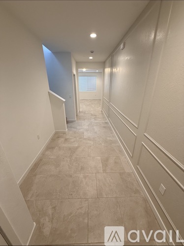 A long hallway with tiled floors and white walls.
