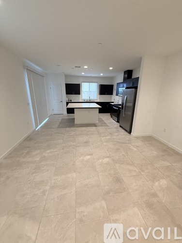 A kitchen area with a refrigerator, sink, and cabinets.