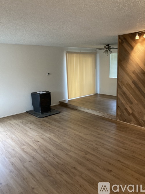 A room with wooden flooring and a black speaker on the floor.