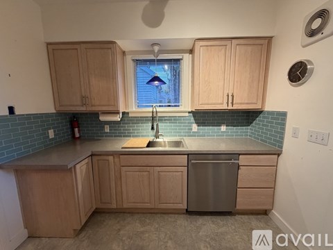 A kitchen with wooden cabinets and a stainless steel dishwasher.