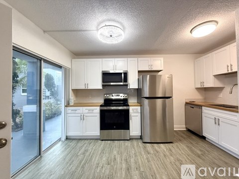 A kitchen with white cabinets and stainless steel appliances.