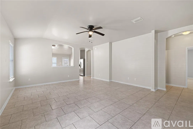 A spacious room with a ceiling fan and tile flooring.