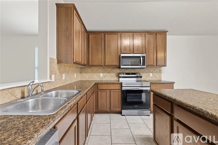 A kitchen with wooden cabinets and a granite countertop.