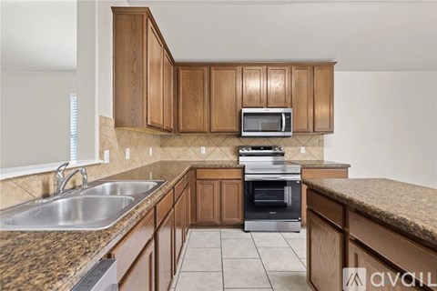 A kitchen with wooden cabinets and a granite countertop.
