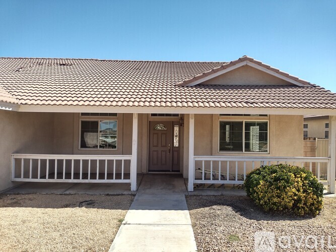 A house with a brown roof and a white fence.