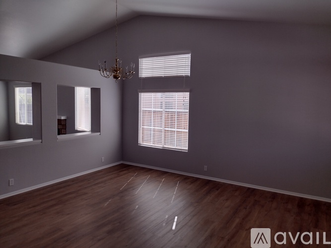 A room with wooden floors and a chandelier.