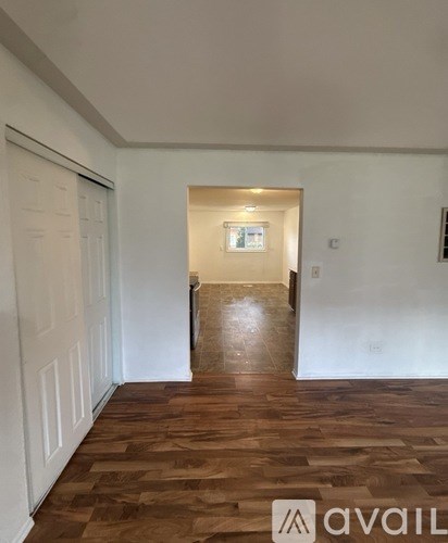 A room with wooden flooring and white walls.