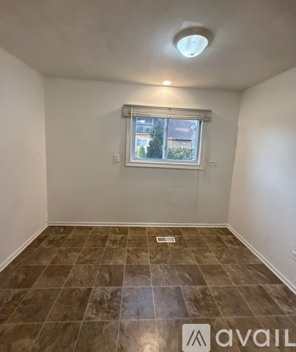 A room with a tiled floor and a window with blinds.