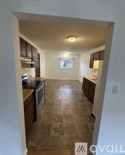 A kitchen with tile flooring and a window in the middle.