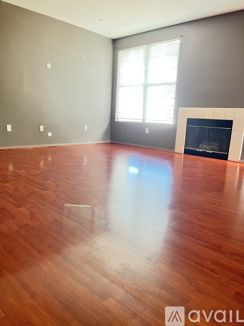 A room with a fireplace and wood flooring.