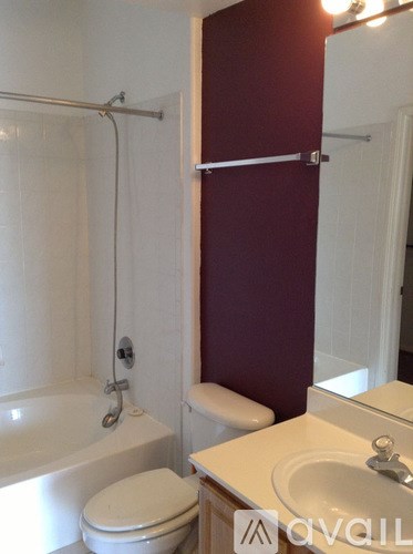 A white toilet sits next to a white sink in a bathroom.