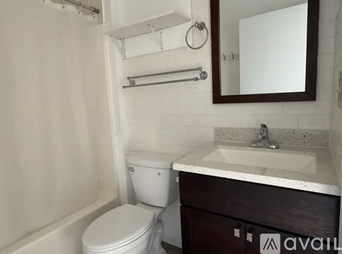 A bathroom with a toilet, sink, and a mirror.