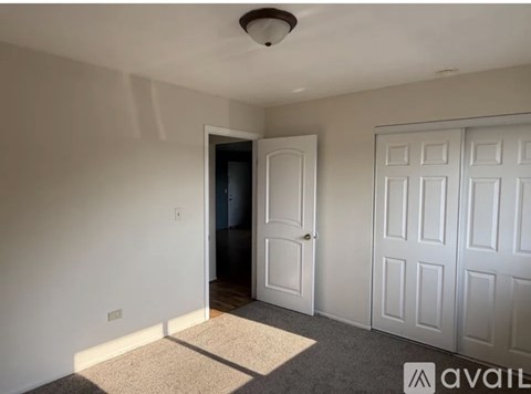 A room with a white door and a carpet on the floor.