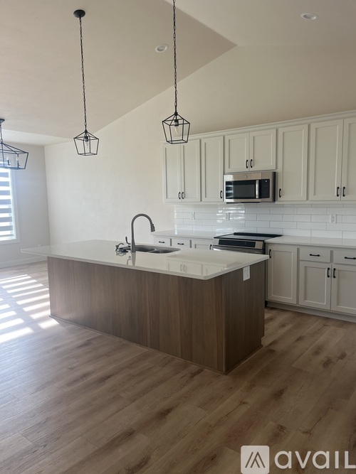 A kitchen with a white countertop and wooden cabinets.