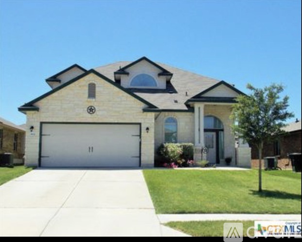 A two-story house with a garage and a driveway.