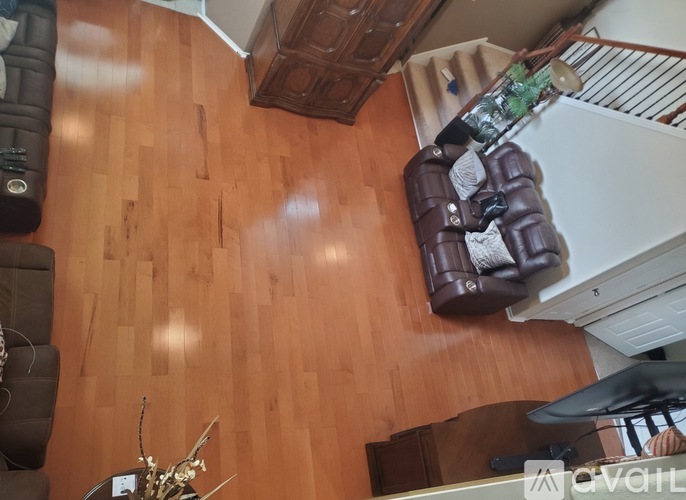 A living room with a brown couch and a wooden floor.