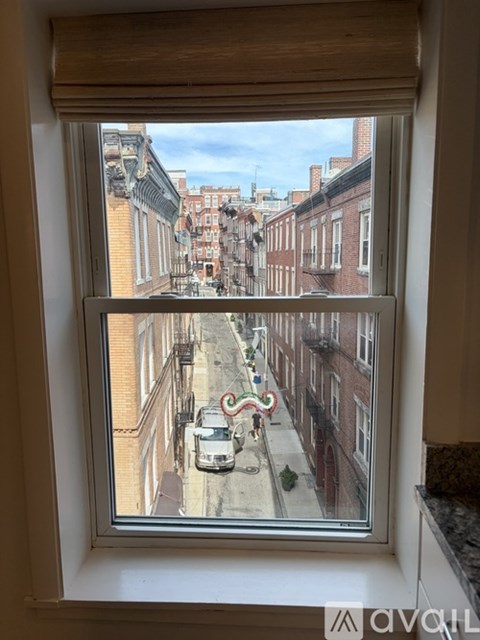A view from a window looking out onto a street with buildings on either side.