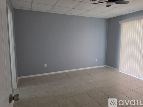 A room with a ceiling fan and a door.