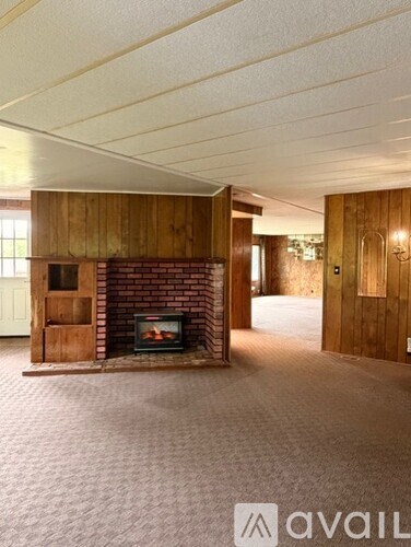 A room with a fireplace and wooden walls.