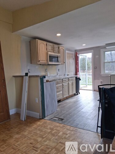 A kitchen with wooden cabinets and a white countertop is shown.