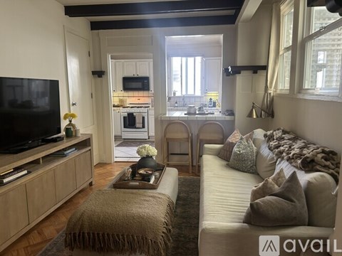 A living room with a couch, a coffee table, and a television.