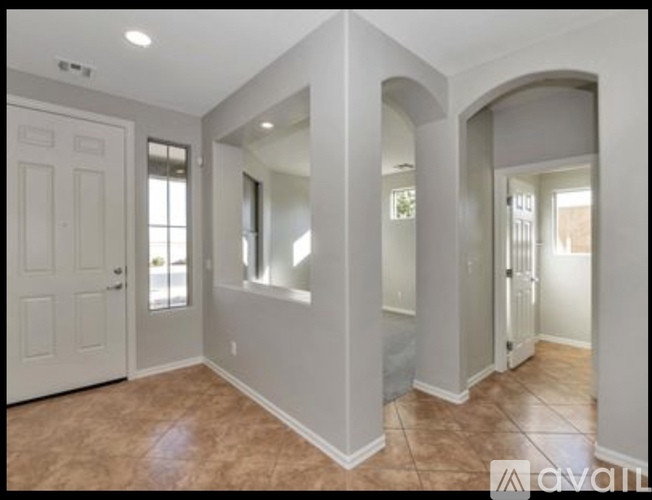 A room with a white door and a window with blinds.
