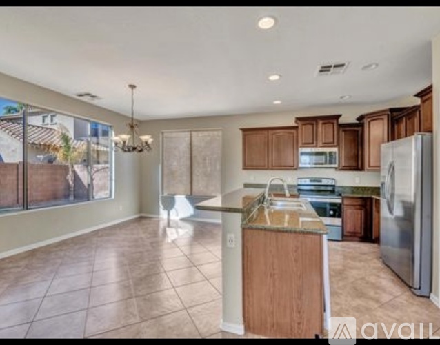 A kitchen with a refrigerator, sink, and cabinets.