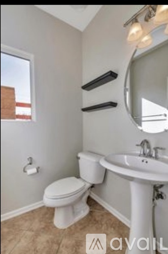 A bathroom with a toilet, sink, and mirror.