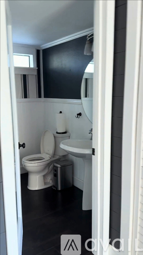 A white toilet and sink in a small bathroom.