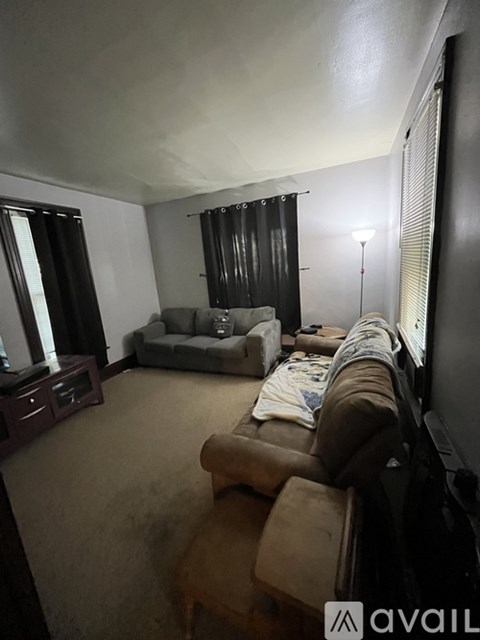 A living room with a couch, chair, and television.
