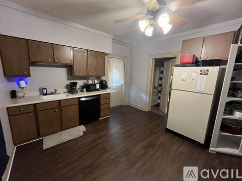 A kitchen with wooden cabinets and a white fridge.