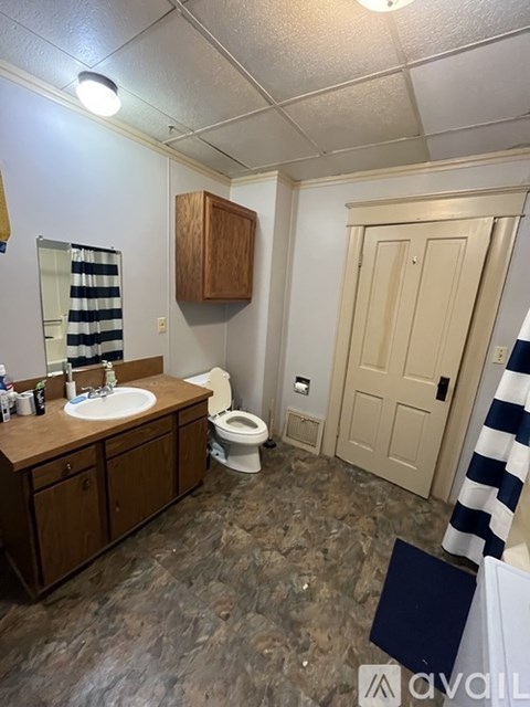 A bathroom with a sink, toilet, and a mirror.