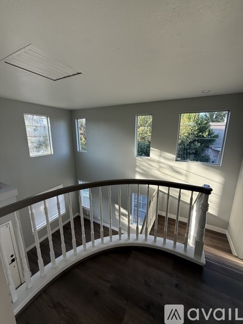 A living room with a white railing and a window.
