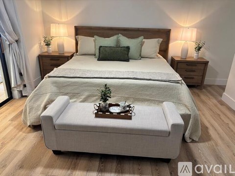 A bedroom with a large bed and a bench in front of it.